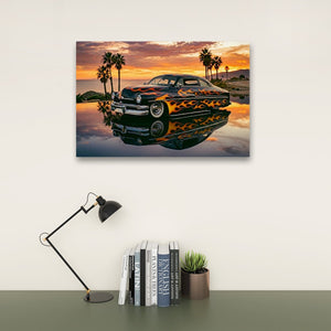 A rectangular wall art print showing a classic car reflected in water at sunset, displayed above a desk with a black lamp, books, and a small succulent on a light wall.