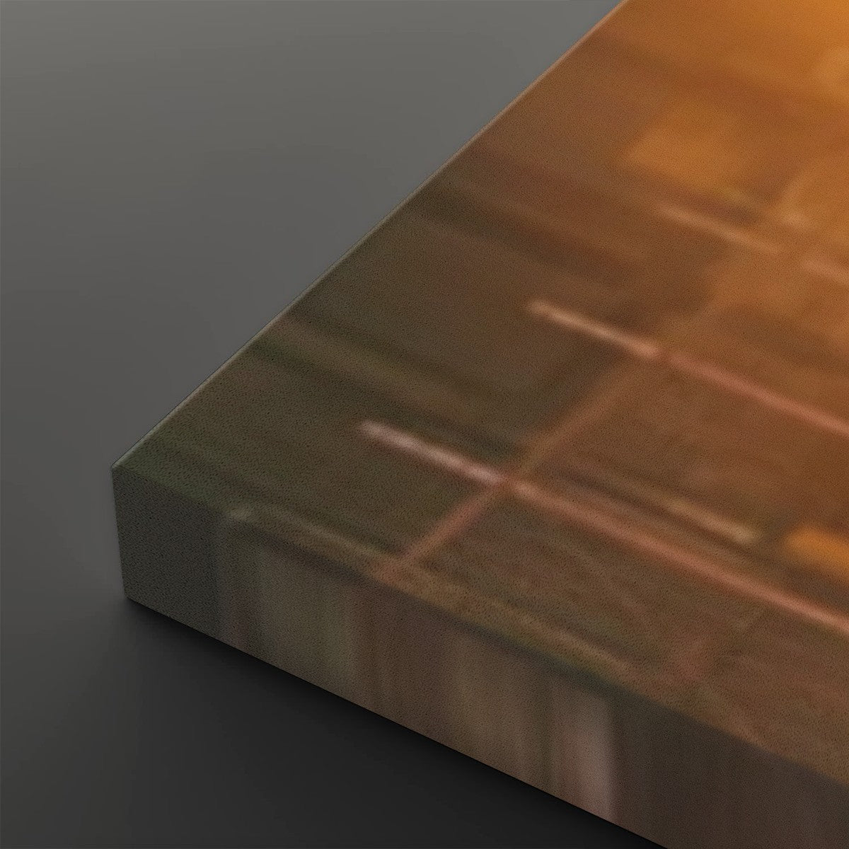 A close-up of a rectangular panel or tile with a warm orange-to-brown gradient and faint linear patterns, shown at an angle on a dark gray background.