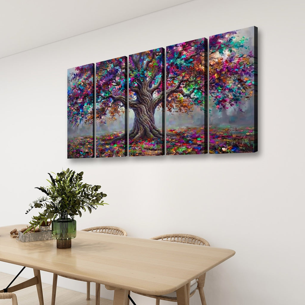 A four-panel canvas wall art set depicting a colorful, textured tree with a brown trunk and vibrant multicolored foliage, displayed on a white wall above a light wood dining table with chairs and a green plant.