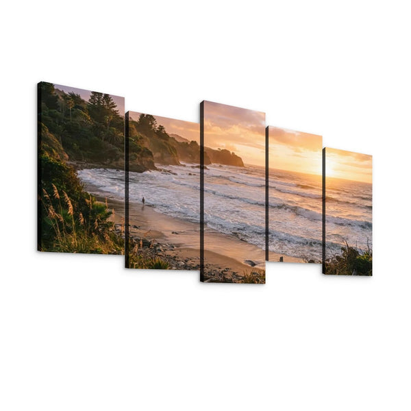 A five-panel split canvas wall art set depicting a coastal beach and ocean at sunset, shown against a plain white background.
