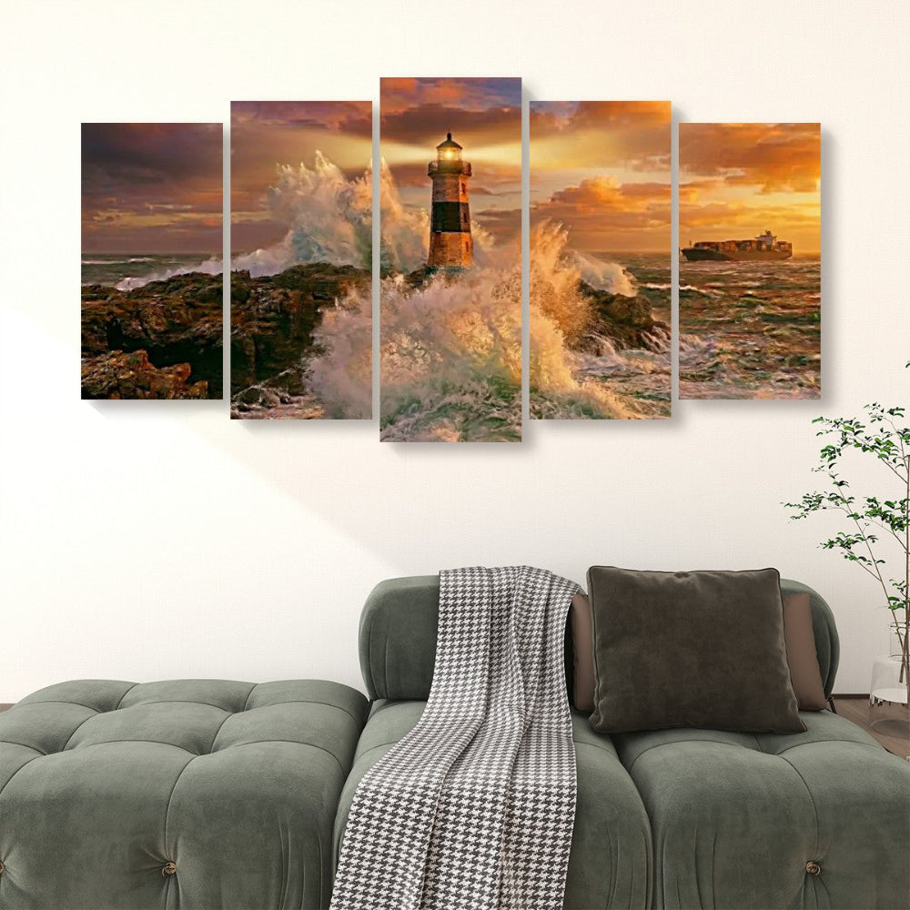 A five-panel canvas wall art set depicting a dramatic lighthouse scene with ocean waves, rocky shore, and a warm sunset sky, displayed above a green sofa in a living room setting.