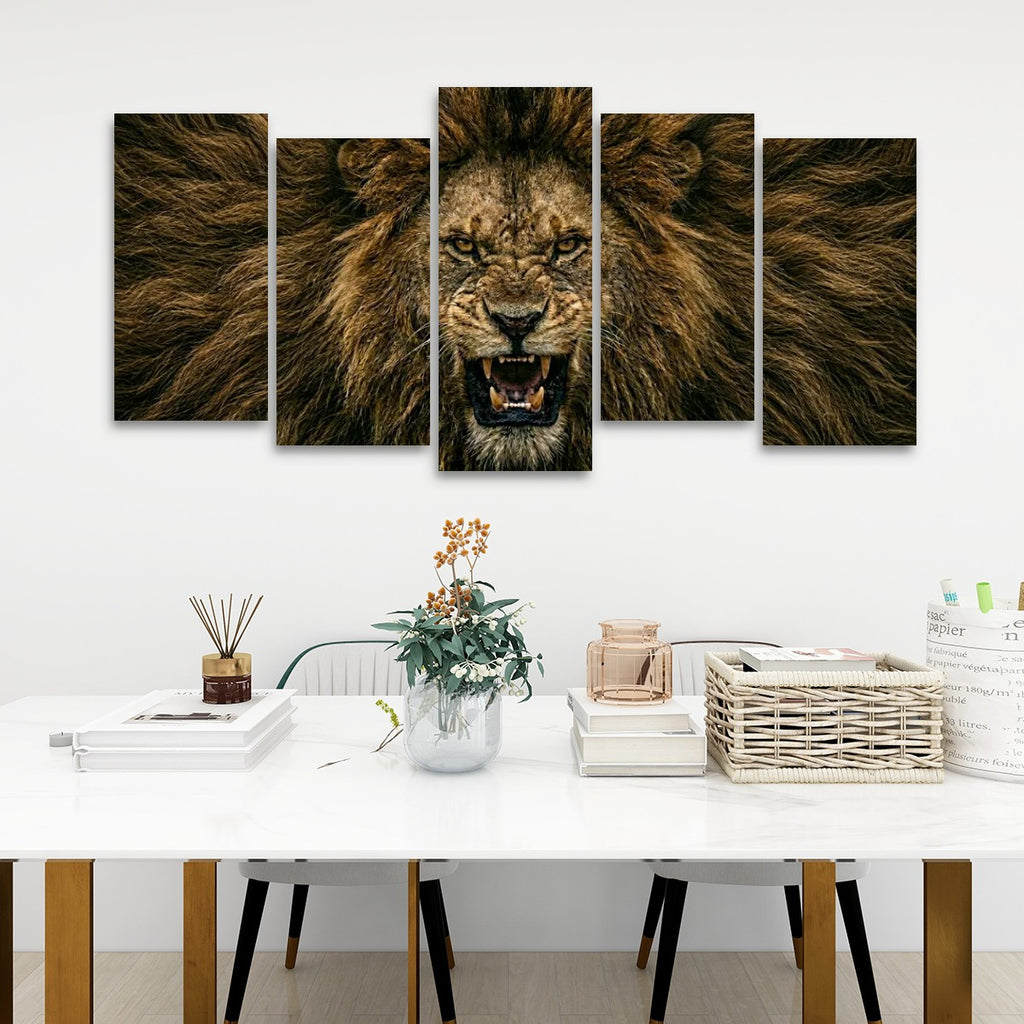 A five-panel canvas wall art set depicting a roaring lion's face and mane, displayed on a white wall above a styled dining table with books, a vase, and a basket.