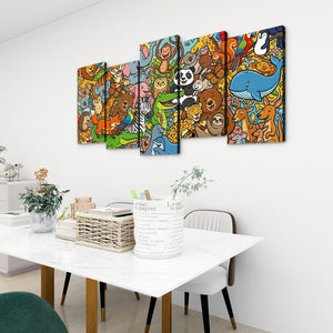 A 5-panel canvas wall art set featuring a colorful cartoon animal scene, displayed on a white wall above a dining table in a modern room setting.