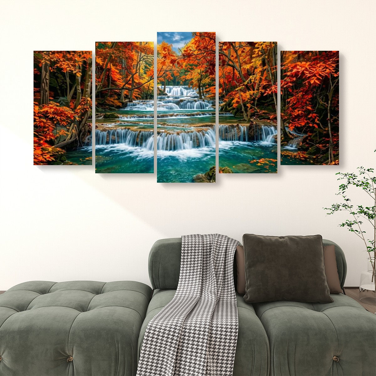 A five-panel canvas wall art set depicting a colorful Huay Mae Khamin waterfall, displayed on a white wall above a green tufted sofa with a throw blanket and pillow.