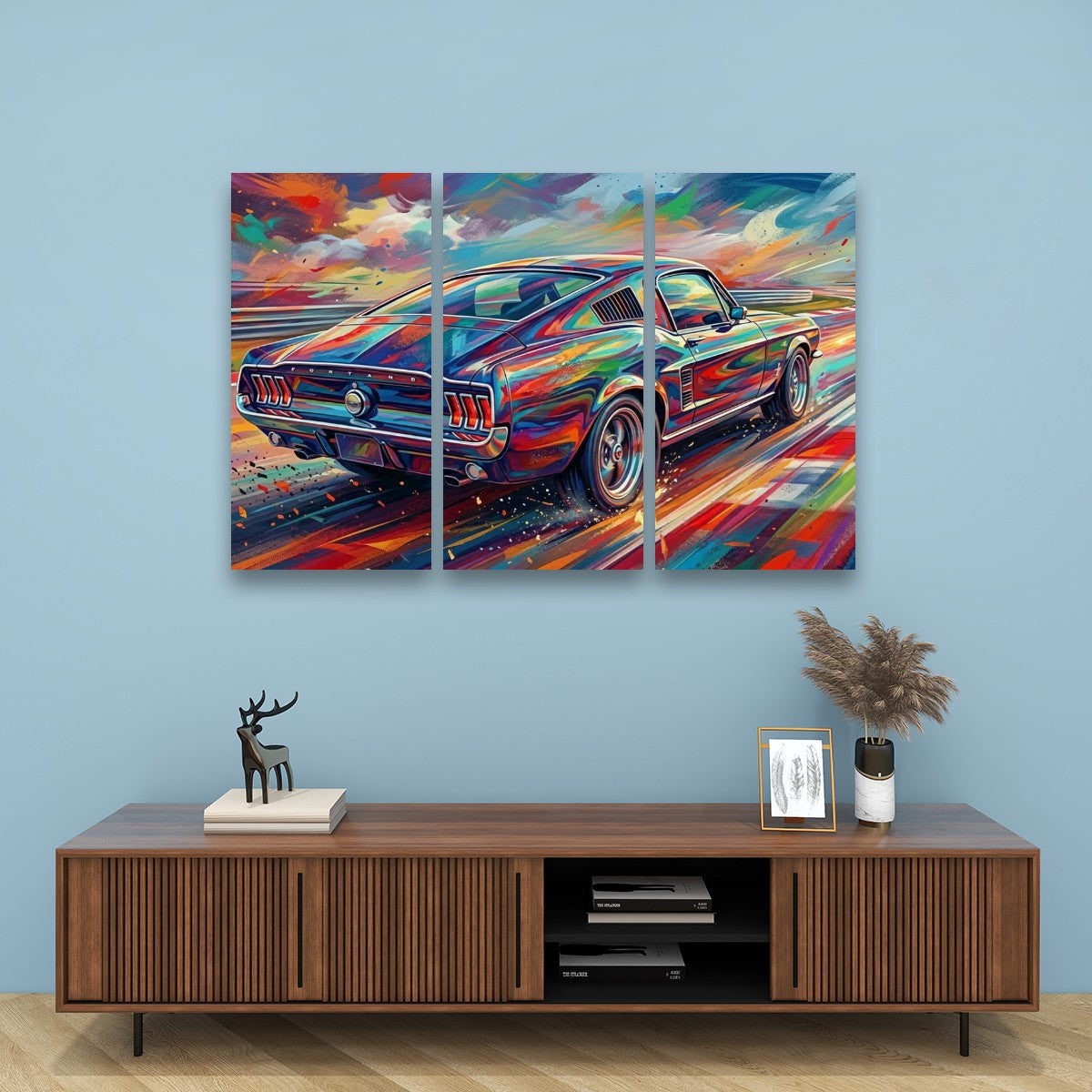 A three-panel canvas wall art print depicting a colorful, impressionistic Mustang car, displayed on a light blue wall above a wooden console table with decorative items.