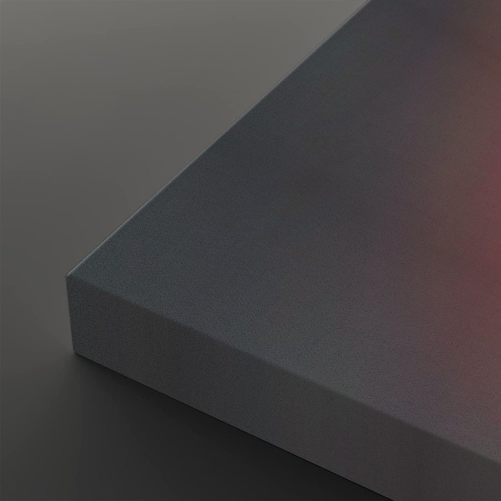 A close-up of a matte gray rectangular panel or block showing its corner and a subtle warm pinkish reflection on one side, set against a matching gray background.