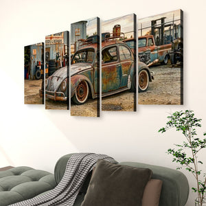 A five-panel canvas wall art set depicting a vintage rusted blue Volkswagen Beetle in an auto repair shop, displayed on a white wall above a green sofa in a living room setting.