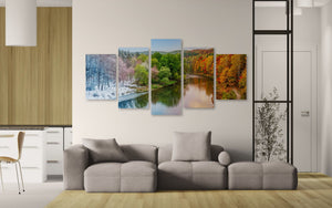 Living room with a sectional sofa and four seasonal landscape paintings on the wall.