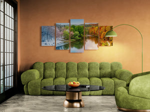 Green sofa in a living room with wall art depicting nature scenes.