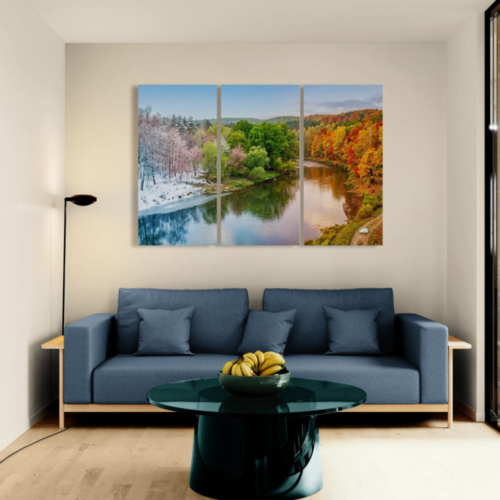 Modern living room with a blue sofa, green coffee table, and large wall art of a river landscape.