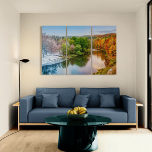 Modern living room with a blue sofa, green coffee table, and large wall art of a river landscape.