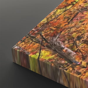 A close-up of a rectangular canvas or print showing an autumn forest scene with orange, yellow, brown, and red leaves, photographed against a dark gray background.