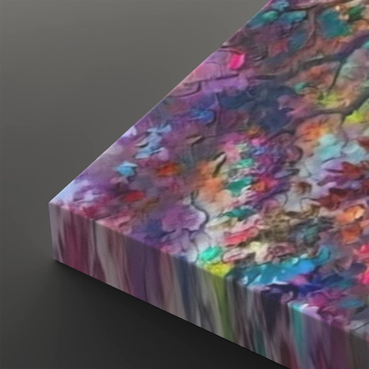 A rectangular canvas print featuring an abstract, colorful floral or painterly pattern in purple, pink, blue, green, yellow, and orange tones, shown at an angle on a dark gray background.
