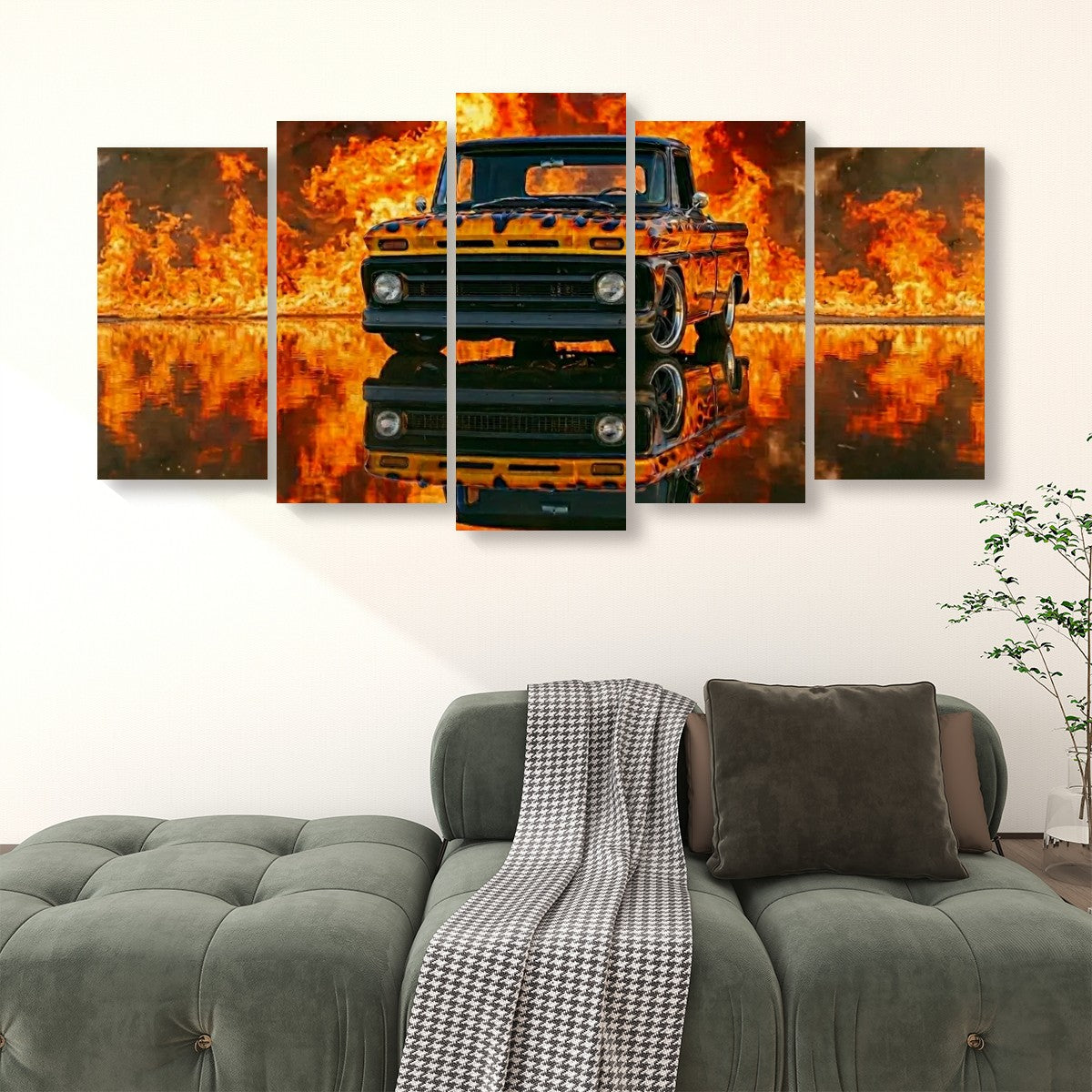 A 5-panel canvas wall art set depicting a black vintage  1966 Chevy C10 Fleetside pickup truck surrounded by bright orange flames and fiery reflections, displayed above a green sofa in a living room setting.