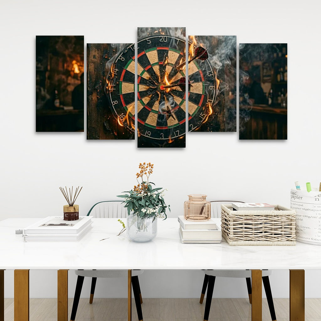 A 5-panel canvas wall art set depicting a burning dartboard, displayed in a modern living room setting above a white table with decorative items.