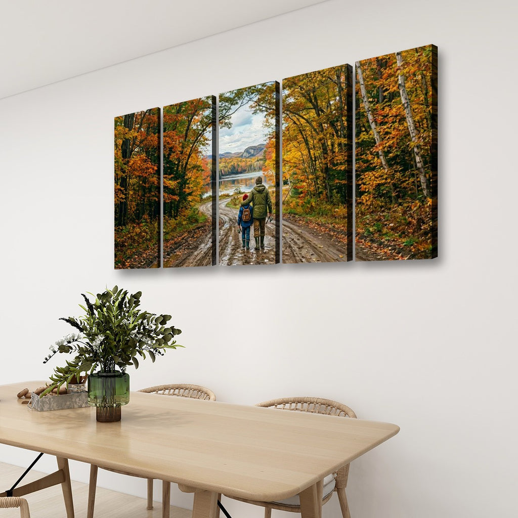 A four-panel canvas wall art print depicting a couple walking on a forest path during autumn, displayed on a white wall above a light wood dining table with chairs and a green plant.