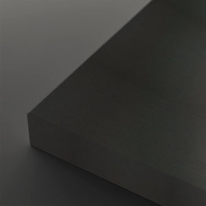 A close-up studio shot of a dark charcoal gray textured rectangular block showing its corner and matte surface against a matching dark gray background.