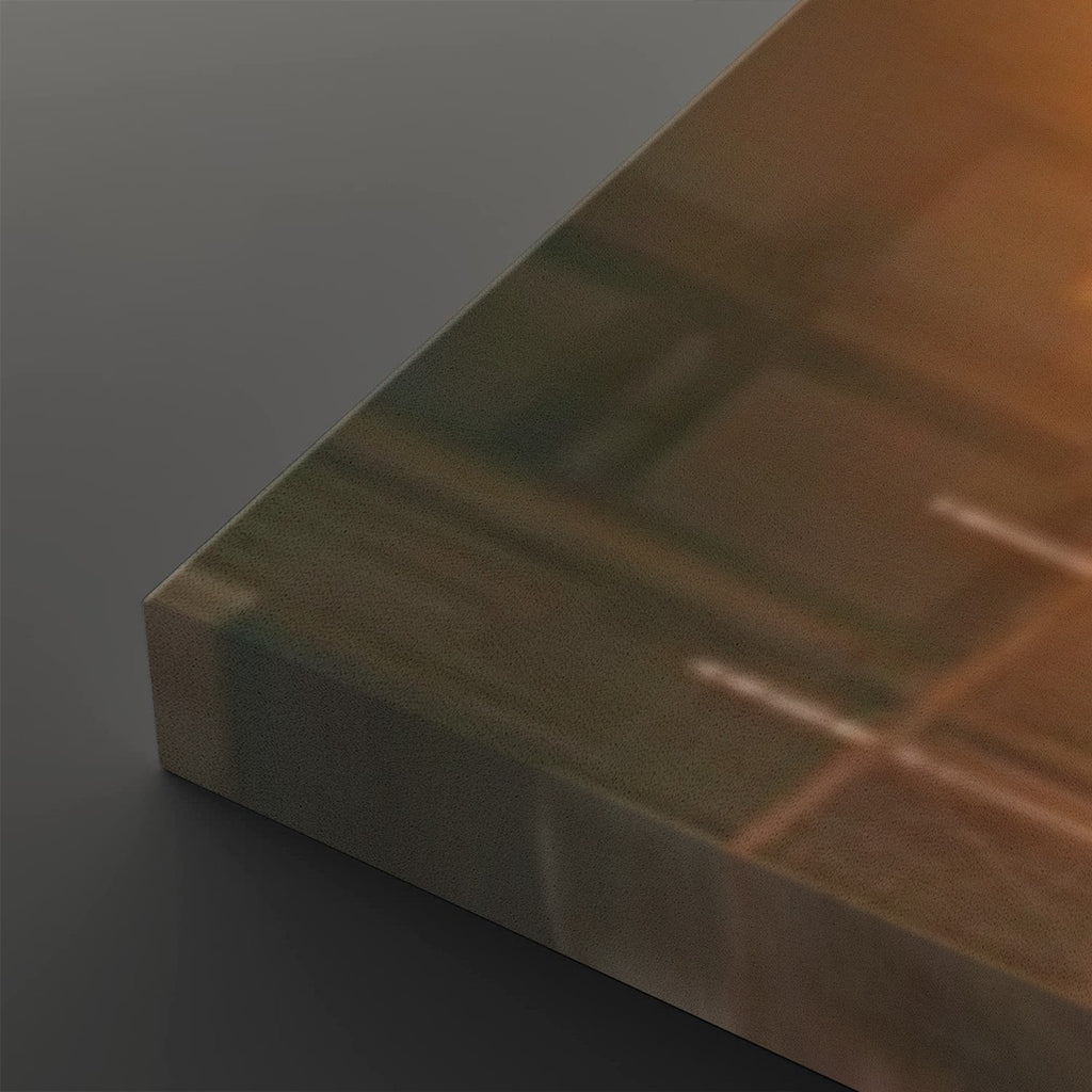 A close-up of a rectangular glass panel or tile sample with a warm amber-brown tint, shown at an angle against a dark gray background.