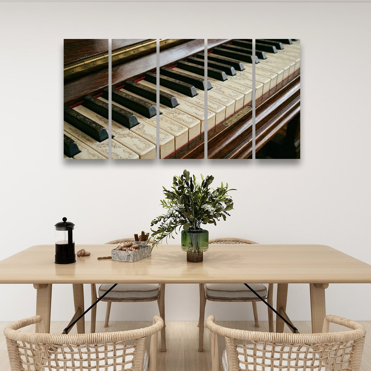 A five-panel canvas wall art print depicting a close-up of vintage piano keys, displayed on a white wall above a wooden dining table with woven chairs and a vase of greenery.