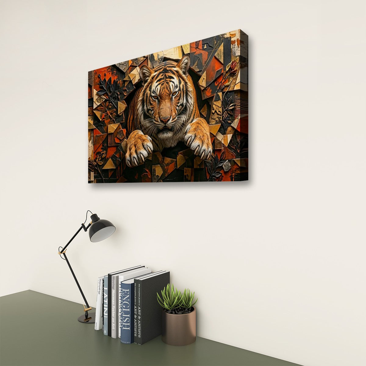 A rectangular wall art print showing a stylized tiger emerging from geometric abstract shapes, displayed above a desk with a lamp, books, and a small plant in a room setting.