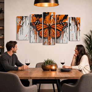 A five-panel canvas wall art set featuring a large orange and black butterfly on a light gray background, displayed above a dining table where a man and woman are seated with wine glasses.