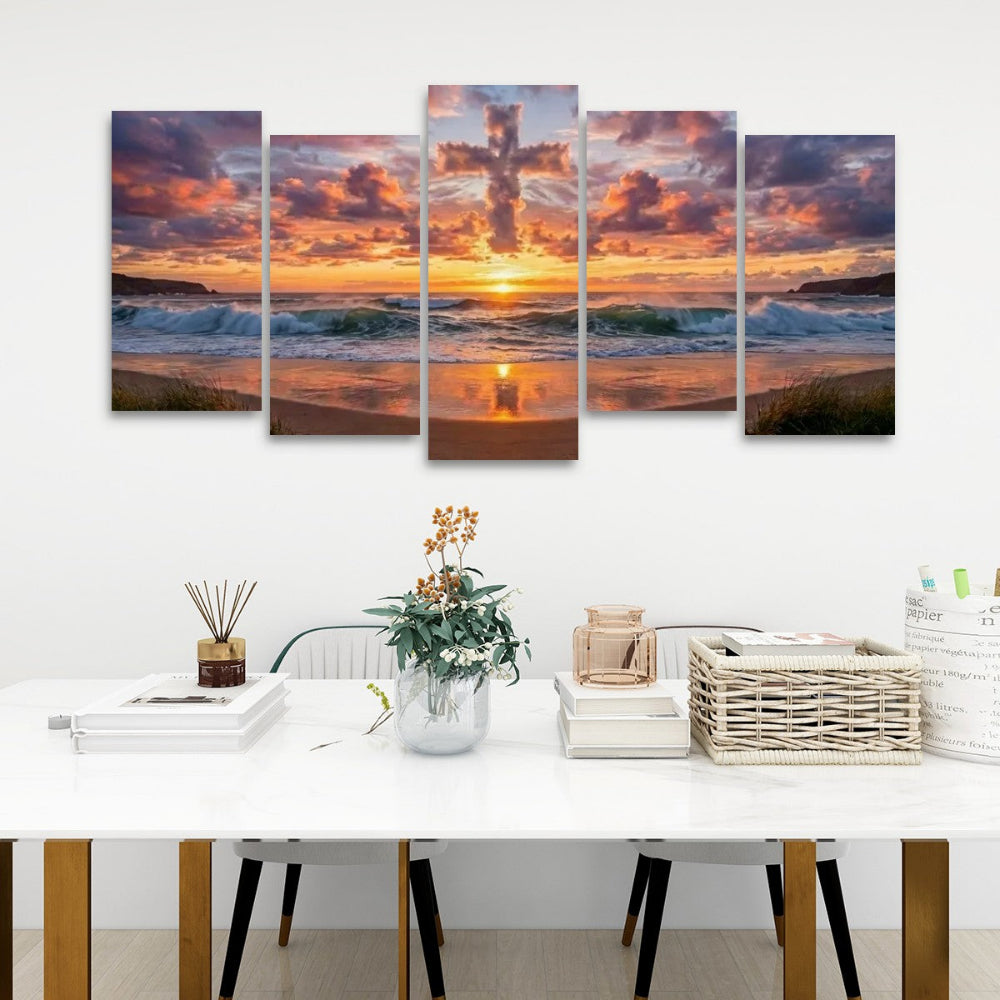 A five-panel canvas wall art set depicting a dramatic sunset over the ocean waves and sandy beach, displayed on a white wall above a modern dining table with books, a vase, and baskets.