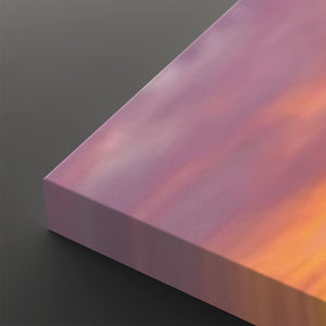 A close-up of a rectangular block or panel with a smooth iridescent surface shifting from pink and lavender to orange, shown against a dark gray background.