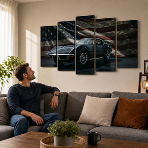 A man sits on a gray sofa in a living room, looking at a five-panel canvas wall art set depicting a black 972 Corvette sports car against a distressed American flag background.