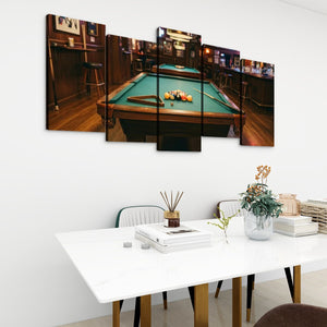 A 5-panel canvas wall art set depicting a pool hall with a green billiards table, displayed on a white wall above a dining table in a modern room setting.