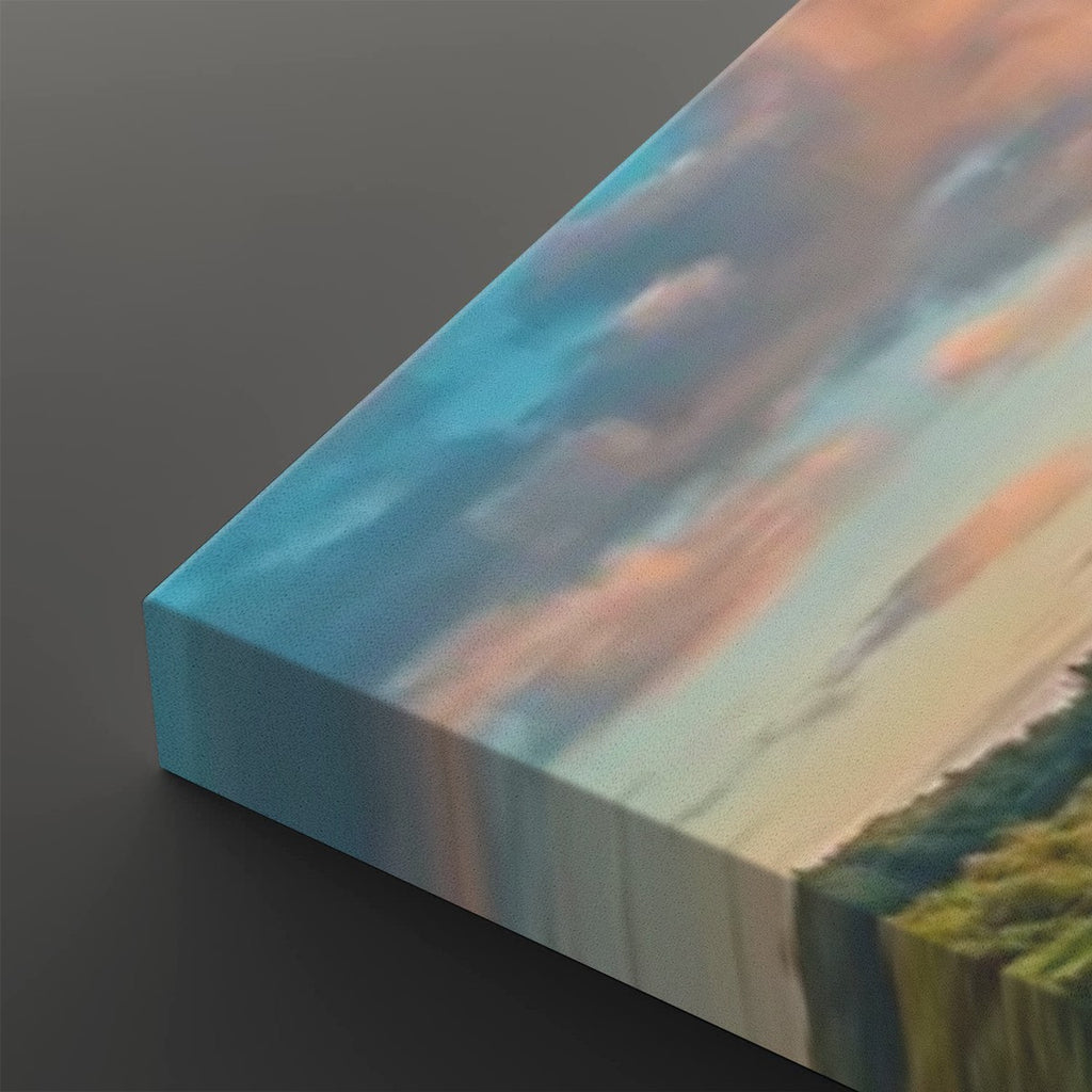 A close-up of a canvas wall art print showing a landscape scene with blue sky, pink clouds, and green trees, photographed at an angle on a dark gray background.