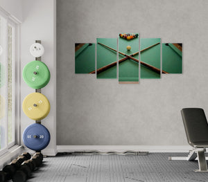 Gym interior with weight plates and a wall art piece of a pool table.