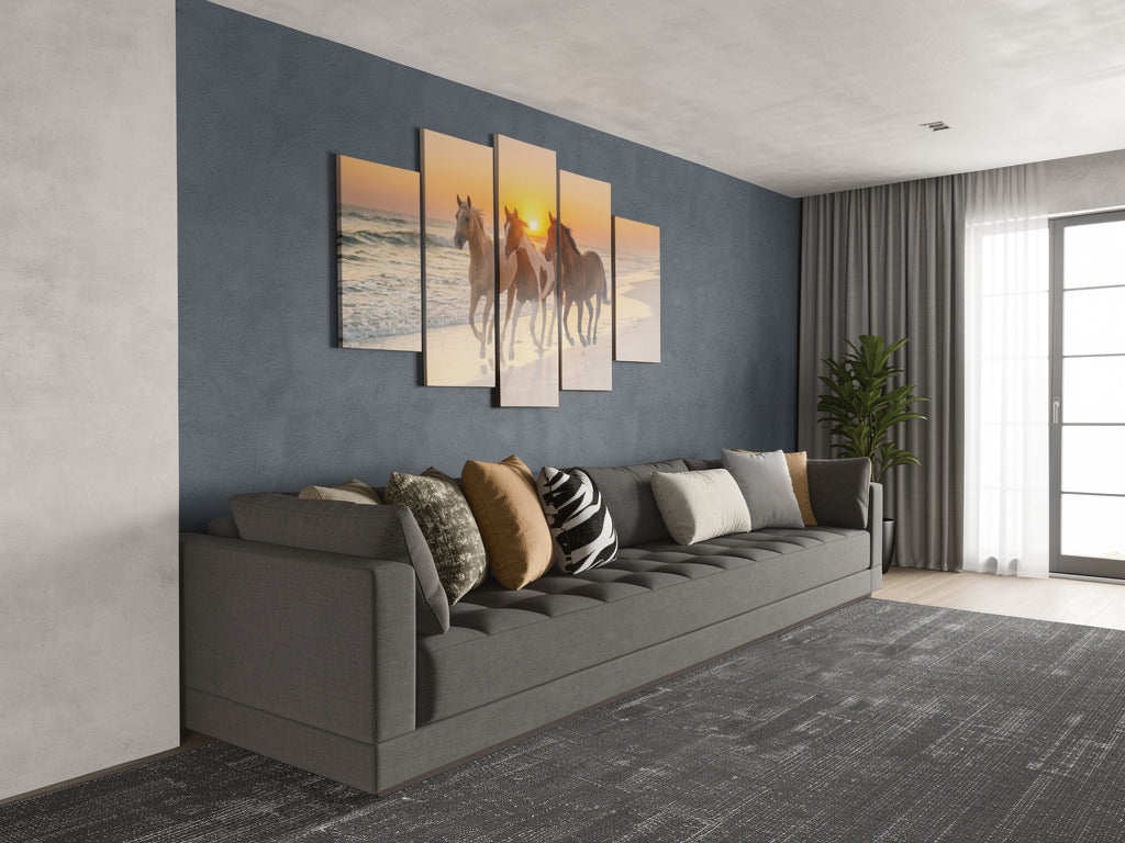 Gray sofa with decorative pillows in a living room with wall art of horses.