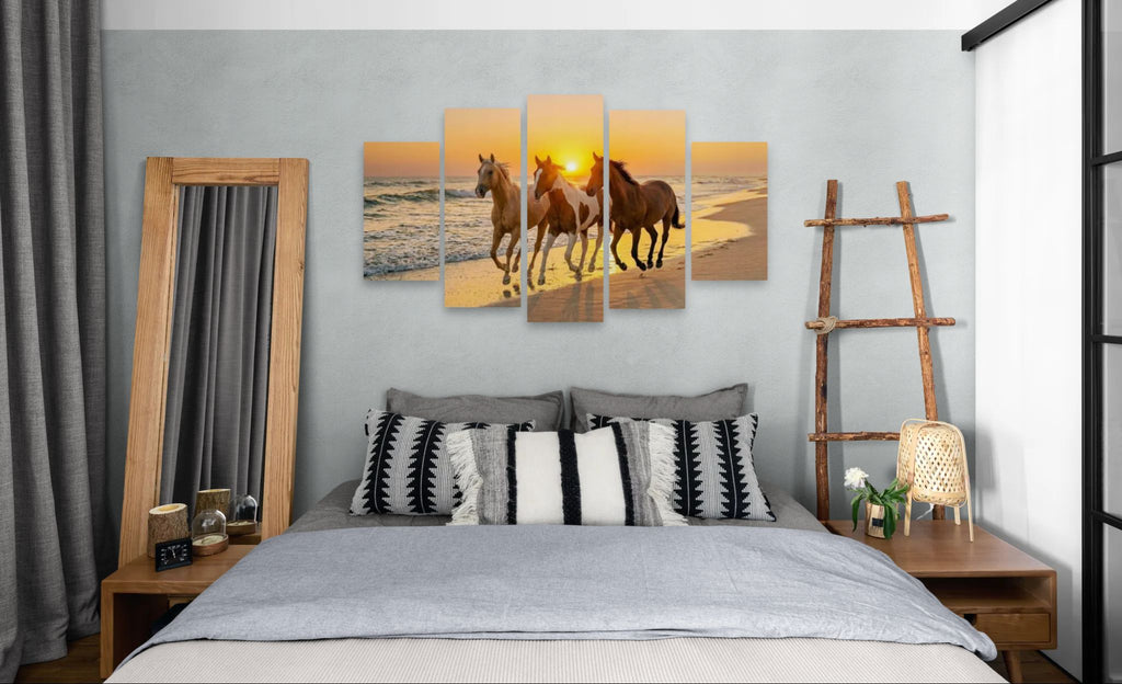 Bedroom with a large wall art piece of horses on a beach at sunset.
