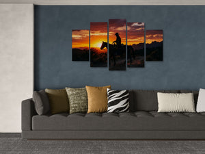 Five-panel wall art of a sunset scene with a horse and rider above a gray sofa with patterned cushions.