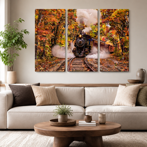 A three-panel canvas wall art set depicting a steam locomotive traveling through an autumn forest, displayed above a modern beige sofa in a styled living room.