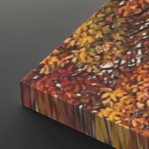 A close-up angled view of a rectangular canvas or print featuring a dense autumn leaf pattern in red, orange, yellow, and brown tones, set against a dark gray background.