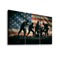 Three-panel canvas wall art showing silhouetted soldiers carrying a wounded comrade in front of a distressed American flag, displayed against a plain white background.