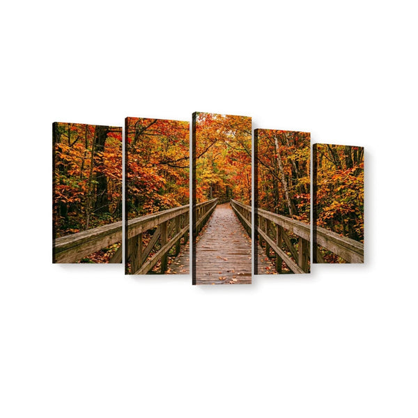 A five-panel canvas wall art set depicting a wooden boardwalk bridge over autumn foliage, shown against a plain white background.