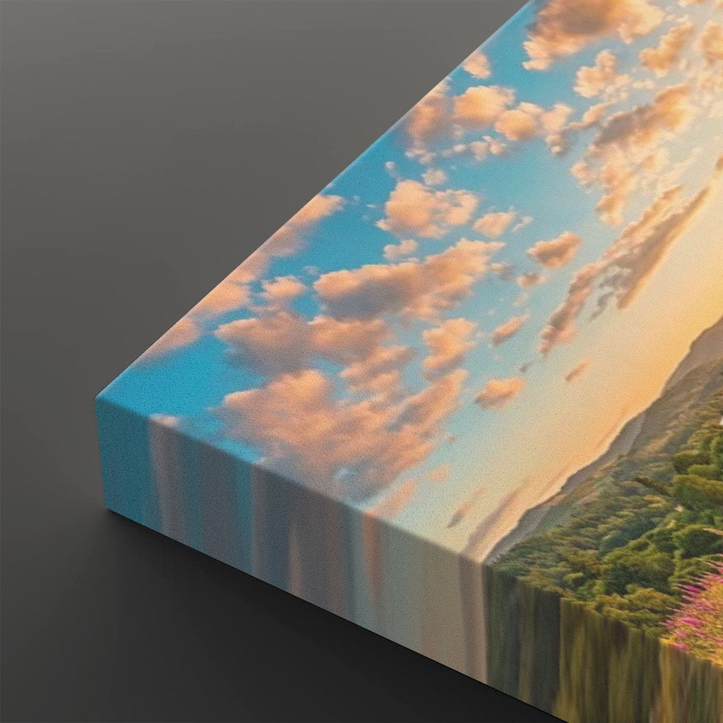 A rectangular canvas wall art print shown at an angle on a dark gray background. The artwork depicts a scenic landscape with a blue sky, soft pink and orange clouds, and green hills.