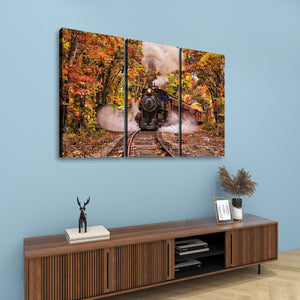 A three-panel canvas wall art set depicting a steam train traveling through an autumn forest, displayed on a light blue wall above a wooden console table with decorative items.