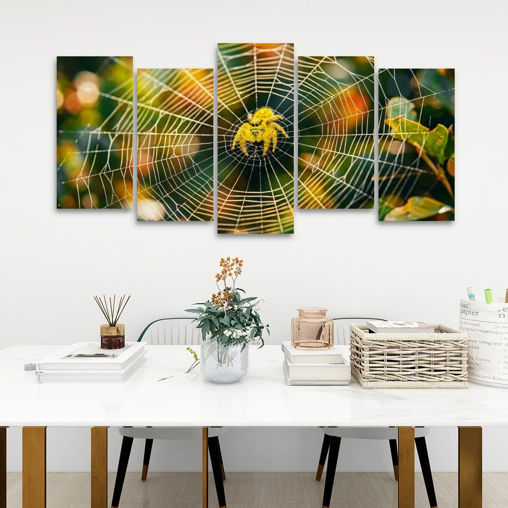 A five-panel canvas wall art set depicting a golden spider on a detailed spiderweb, displayed in a modern living room setting above a white table with decorative items.