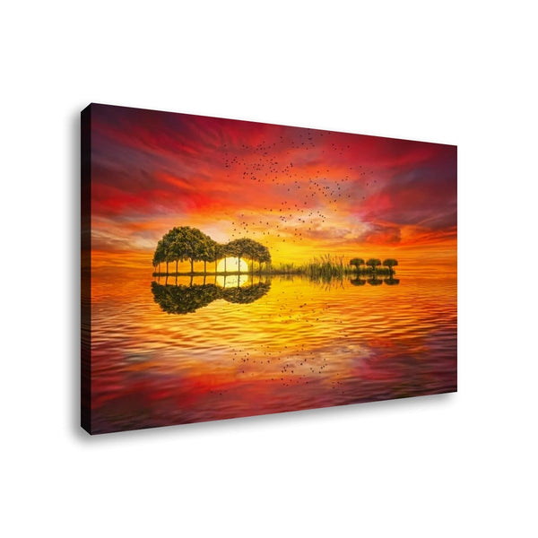 A rectangular canvas wall art print shown at an angle against a plain white background. The artwork depicts a vivid sunset or sunrise over calm water, with a tree island in the center and a bright glowing reflection on the surface.