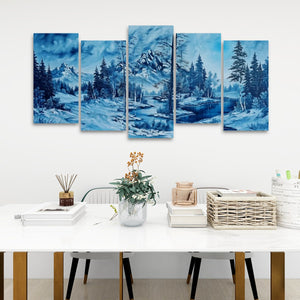 A five-panel canvas wall art set depicting a snowy mountain landscape in shades of blue, displayed on a white wall above a styled dining table with books, a vase, and a basket.