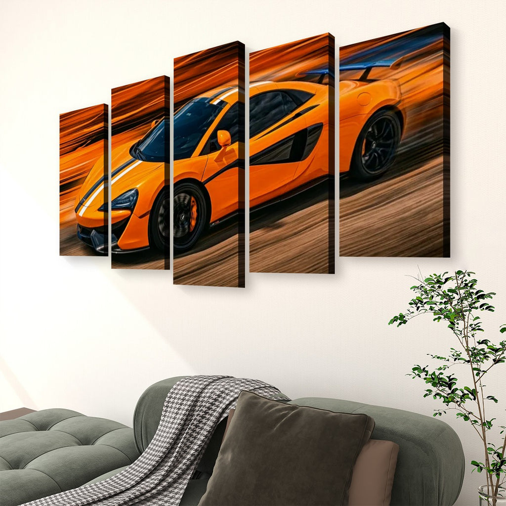 A five-panel canvas wall art set depicting a bright orange sports car in motion, displayed above a green sofa in a modern living room setting.