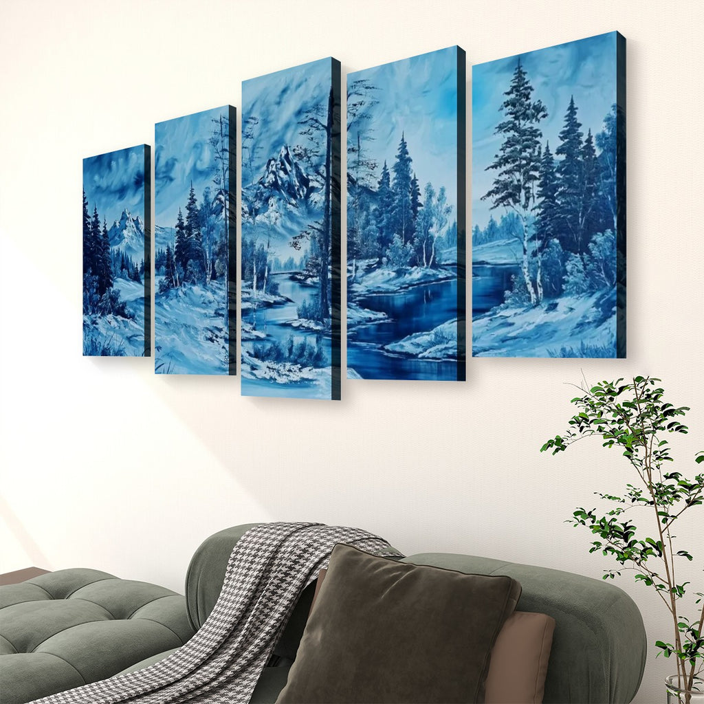 A five-panel canvas wall art set depicting a snowy blue winter landscape with trees and a river, displayed above a green sofa in a living room setting.