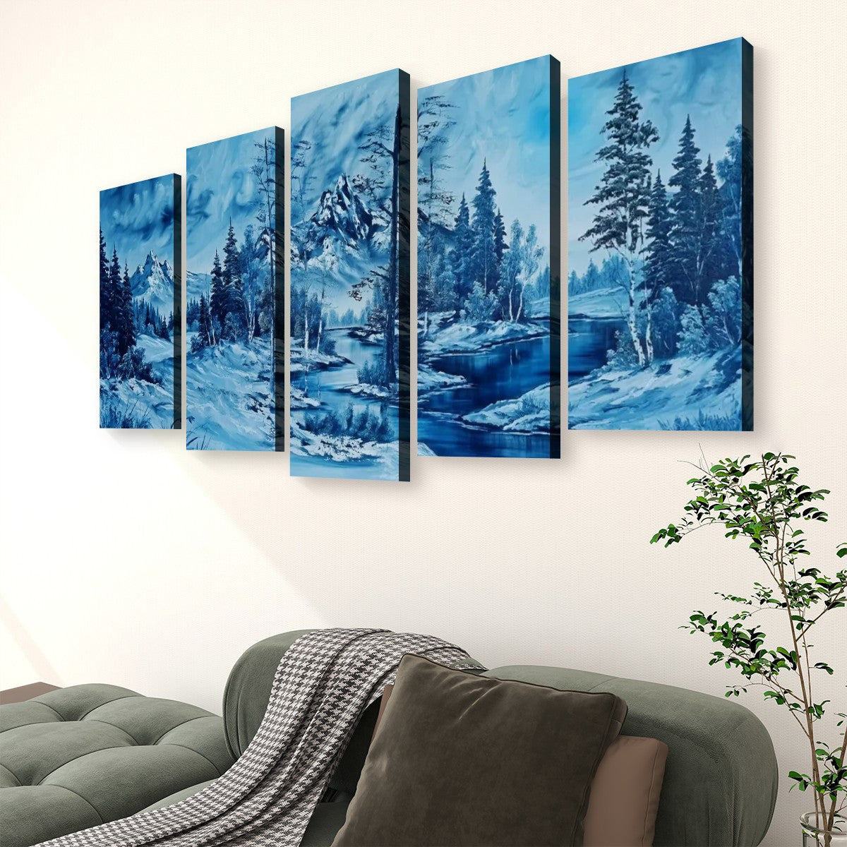 A five-panel canvas wall art set depicting a snowy blue winter landscape with trees and a river, displayed above a green sofa in a living room setting.