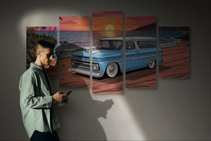 Man standing in front of a wall with a large canvas print of a blue vintage car and sunset scene.