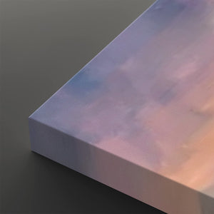 A close-up of a rectangular canvas or panel with a soft iridescent pastel surface showing lavender, pink, and blue tones, photographed on a dark gray background.