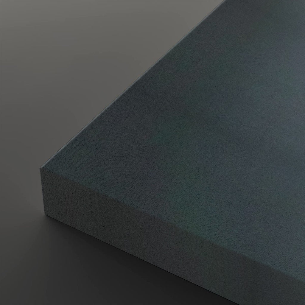 A close-up studio shot of a rectangular panel or board corner, shown at an angle against a dark gray background. The surface has a subtle iridescent or oil-slick-like finish shifting between blue, teal, and gray tones.