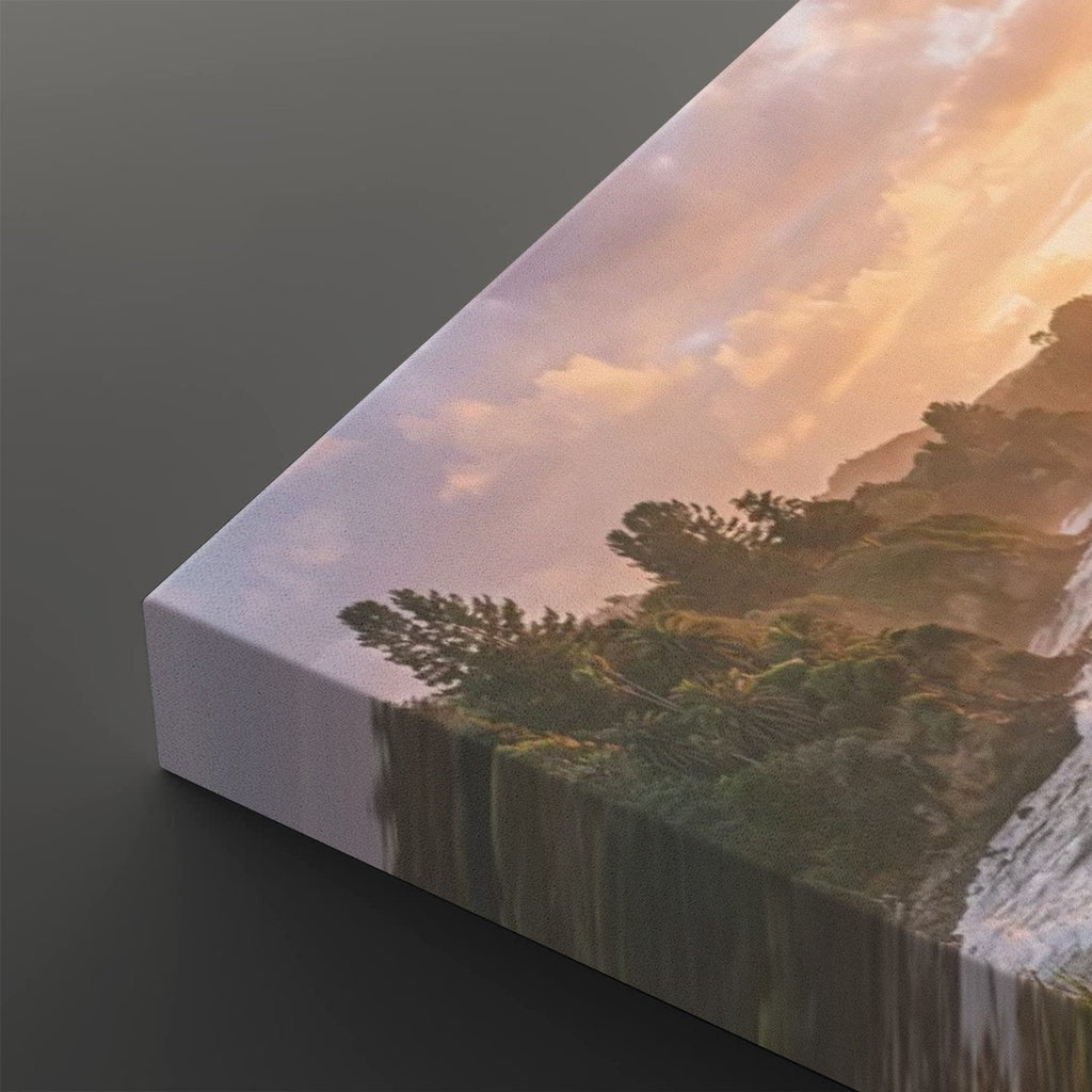 A rectangular canvas wall art print shown at an angle on a dark gray background. The artwork depicts a scenic landscape with trees, mountains, and a glowing sunset sky.